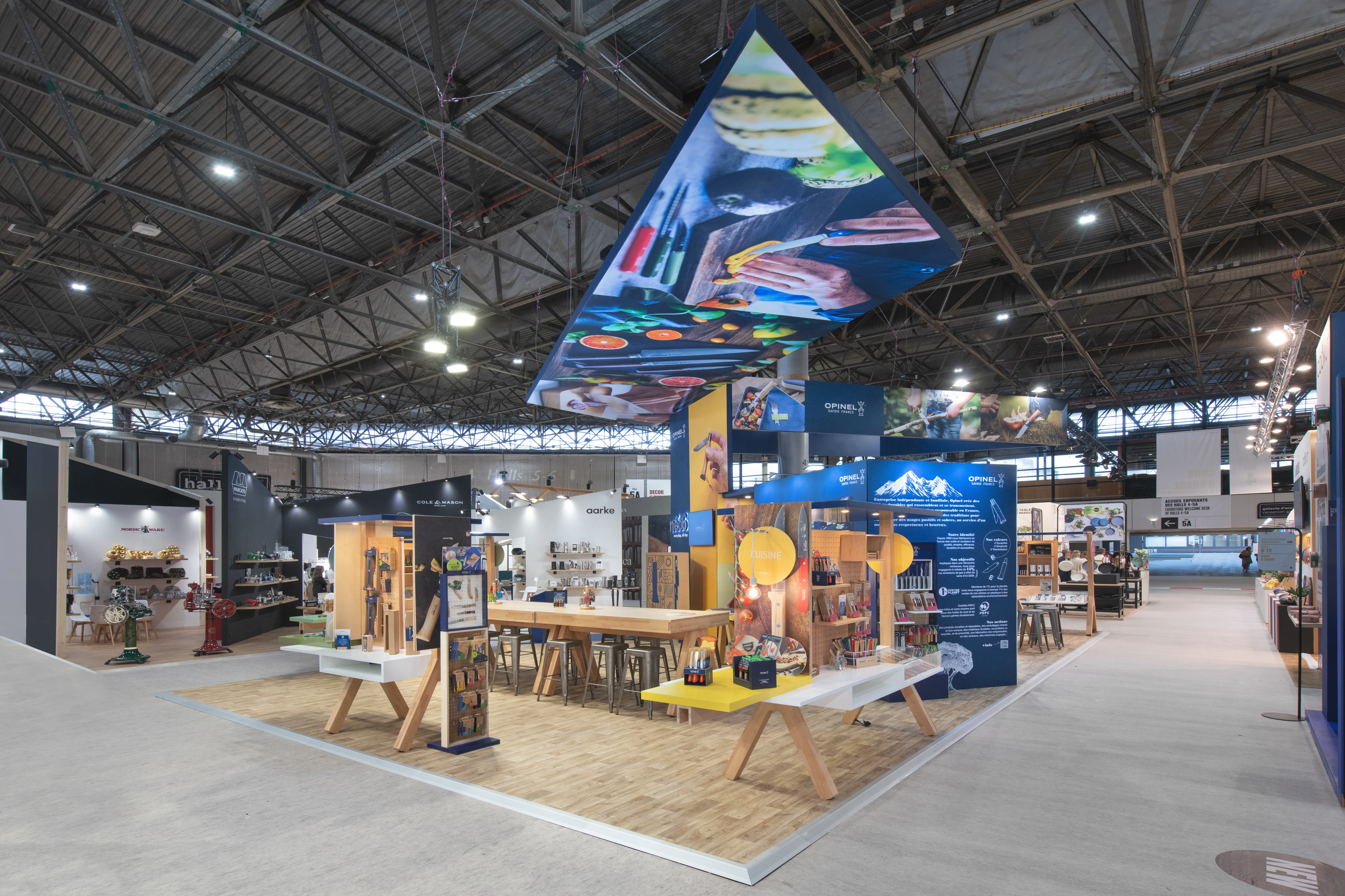 vue générale du stand Opinel 2025 avec plafond imprimé et parcours thématique