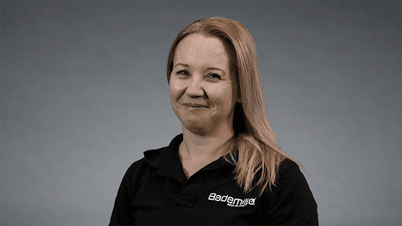 Anita Ingierd markedssjef Bademiljø i sort skjorte med Bademiljø logo foran nøytral grå bakgrunn