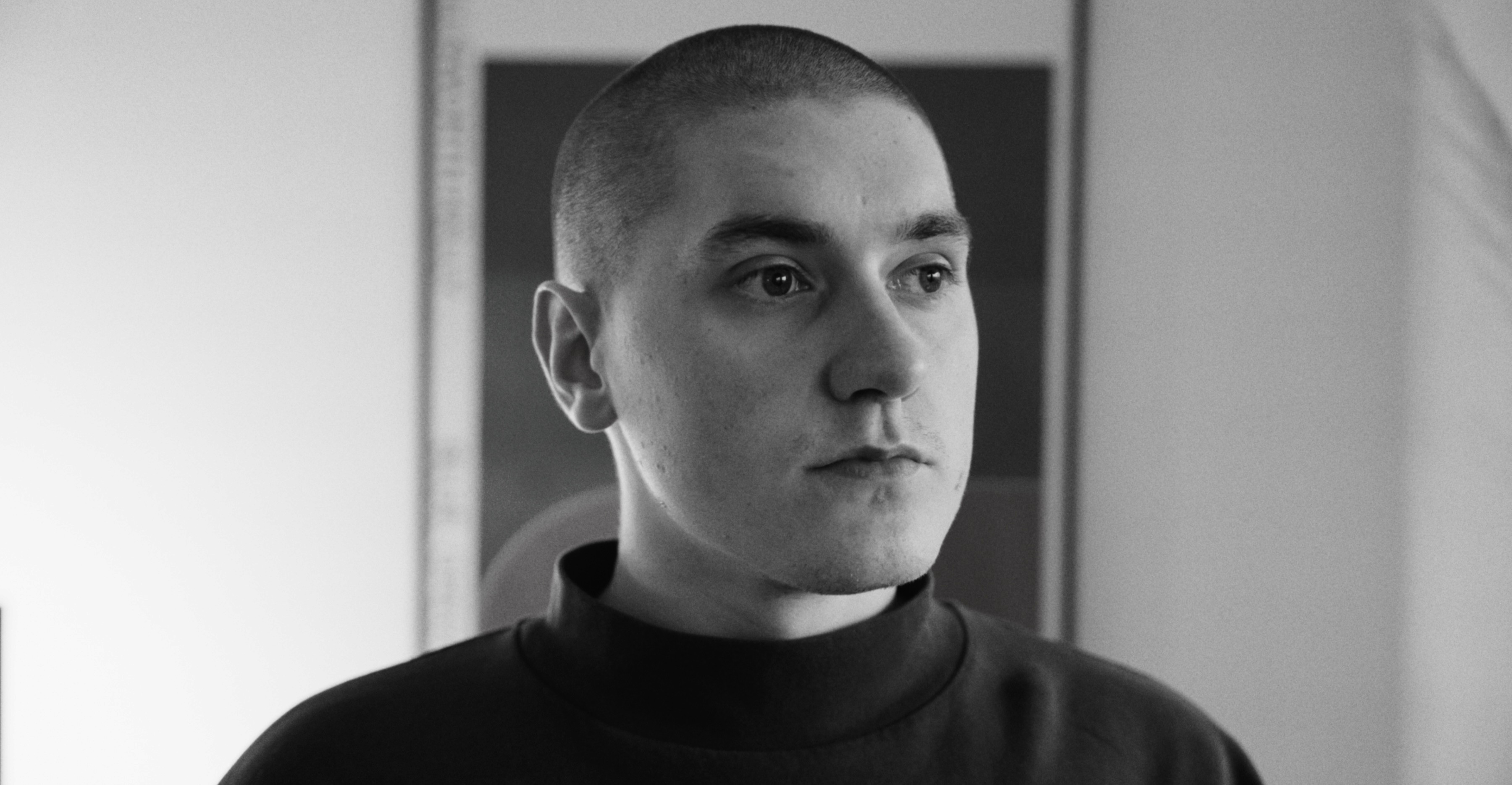 A street scene in Tokyo at night. Neon red dominates the right frame.