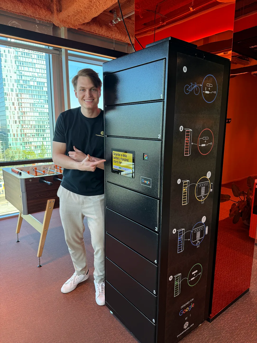 PowerShelter SmartShelter e-bike battery charging locker installed at Google Amsterdam, showing the touchscreen interface and step-by-step usage guide
