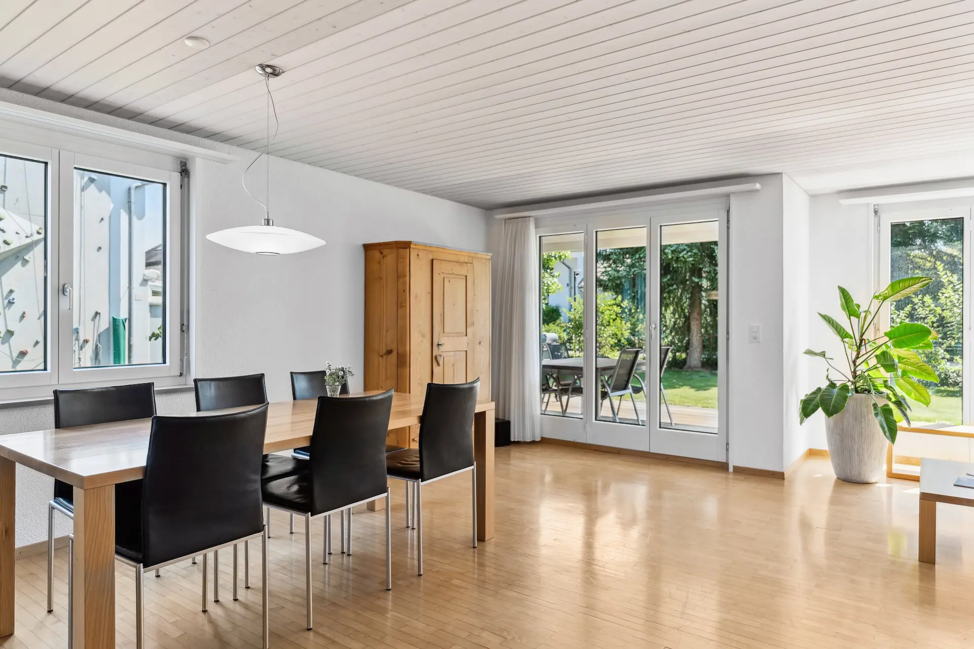 Esszimmer mit weisser Holzdecke und Zugang zum Gartensitzplatz