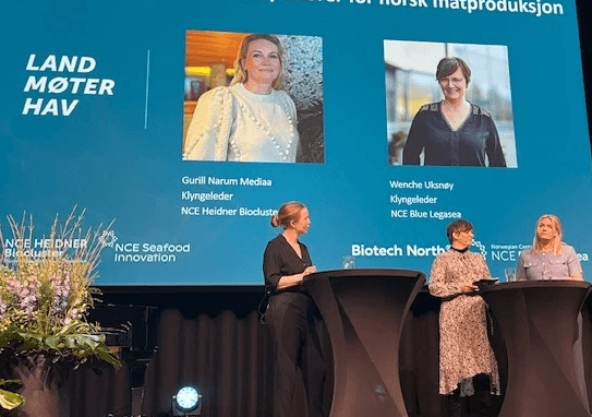 A person wearing a virtual reality headset stands in front of multiple screens, engaged in a digital experience.