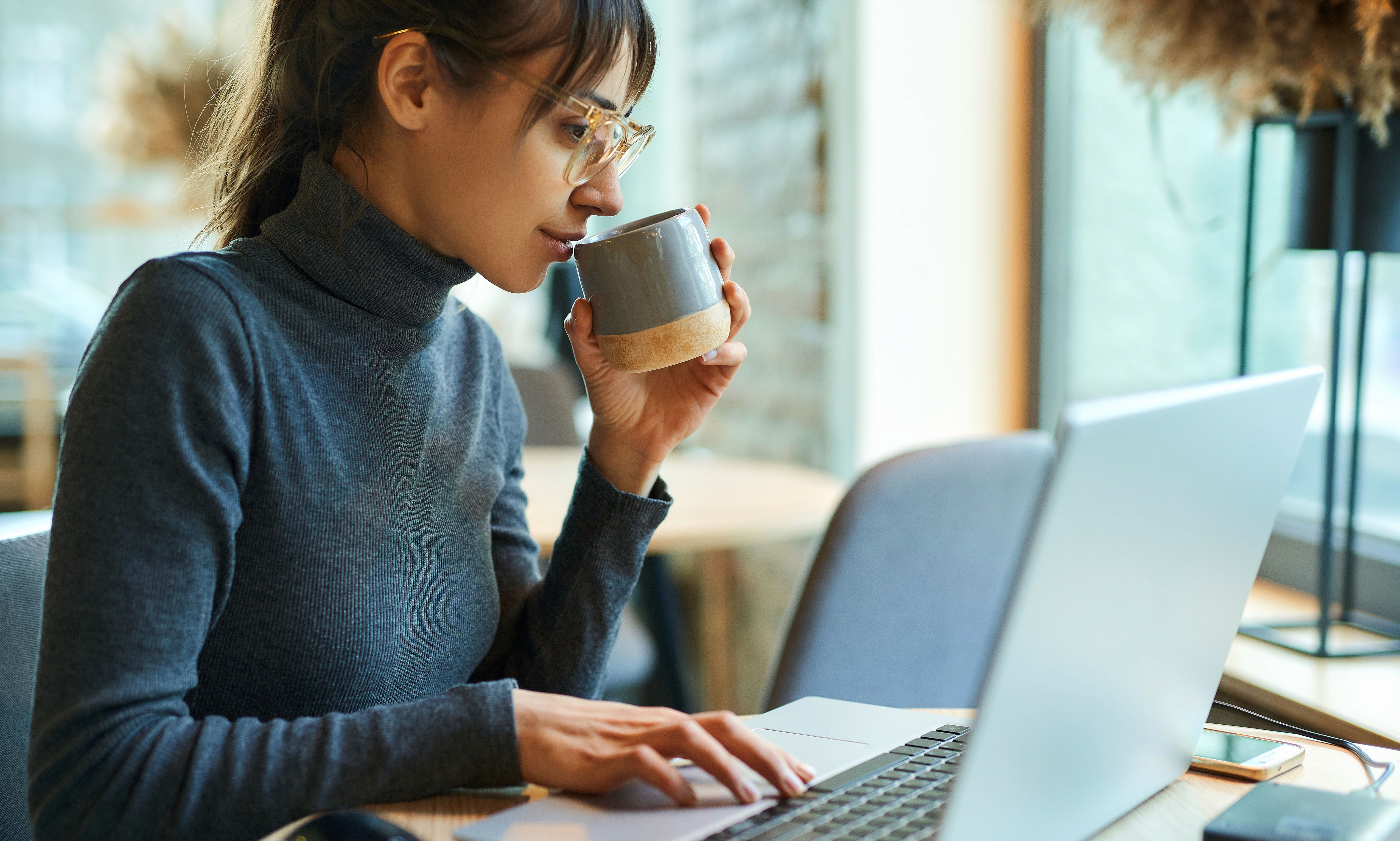 A maroon passport, a credit card, and a document are placed on a dark surface.