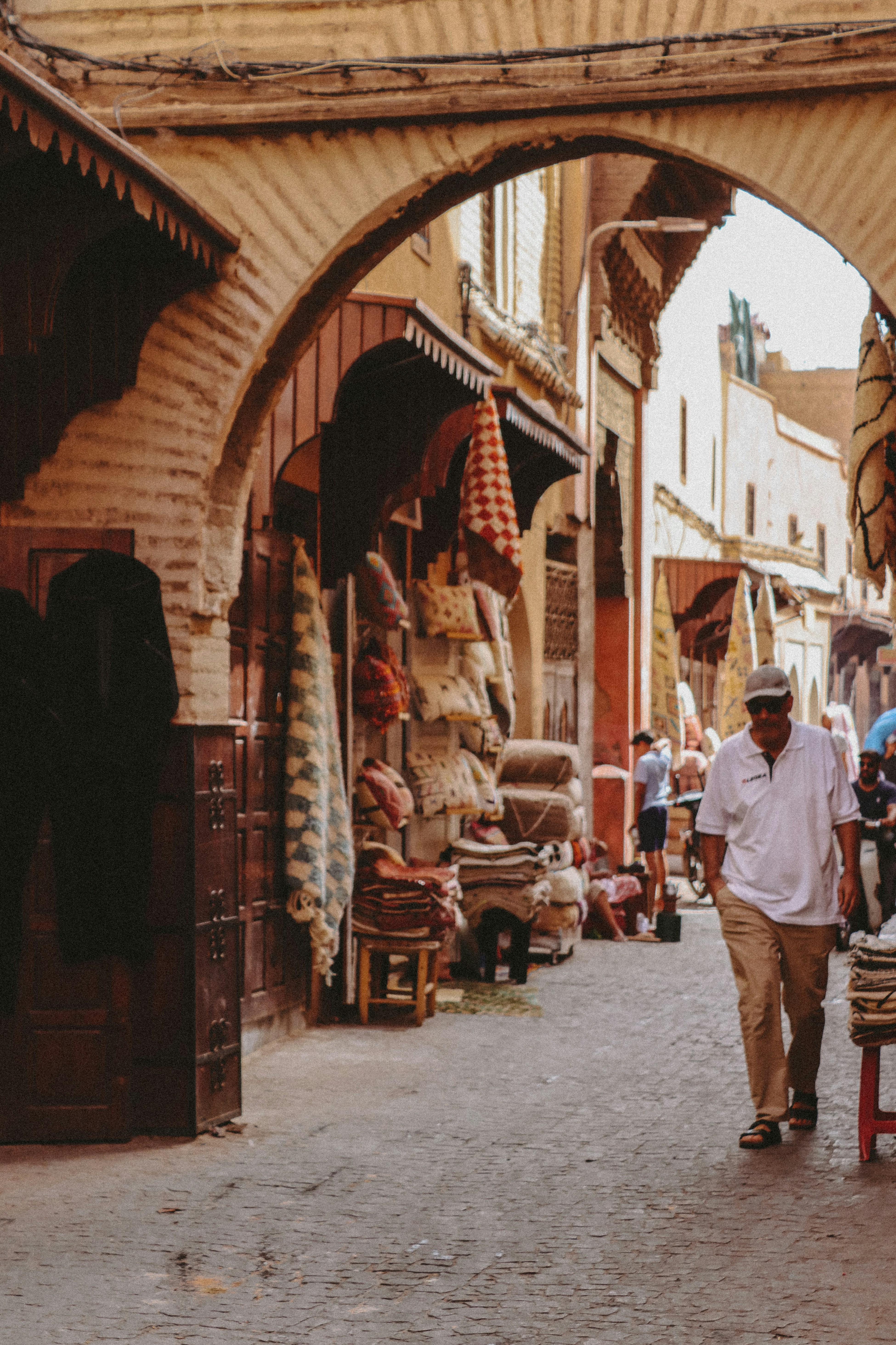 A man walking down a street next to a building
