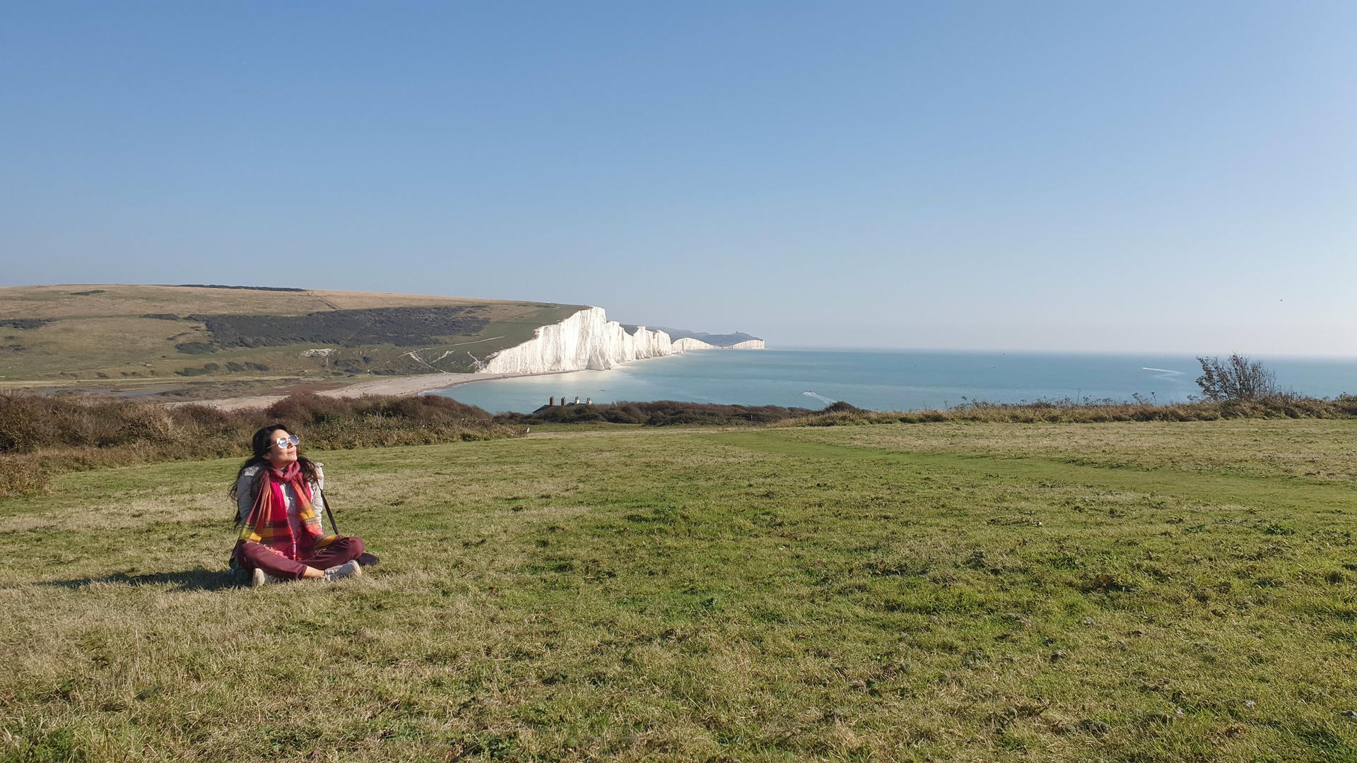 Samira standing at edge of cliff looking at clouds