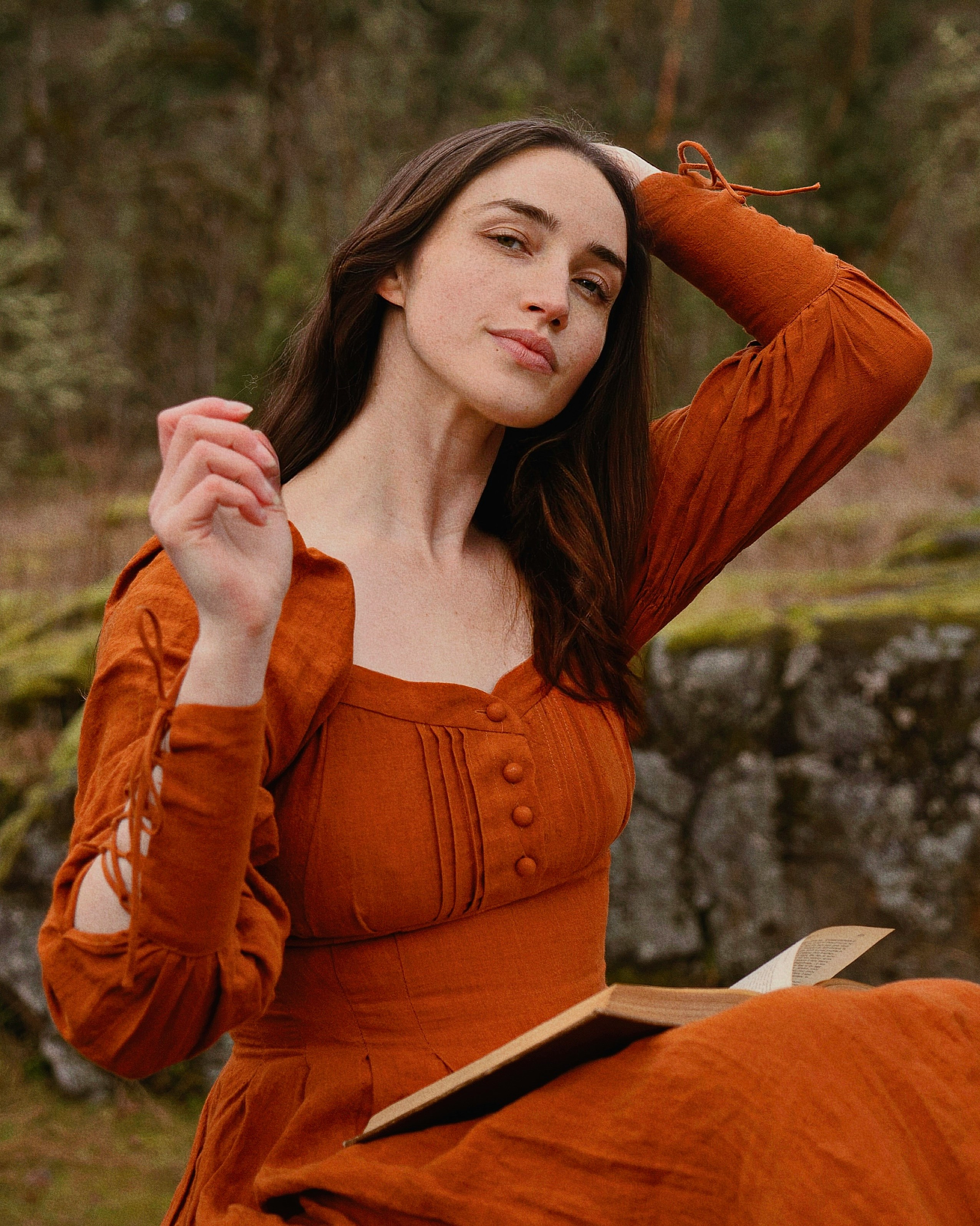 a woman in an orange dress is holding a book