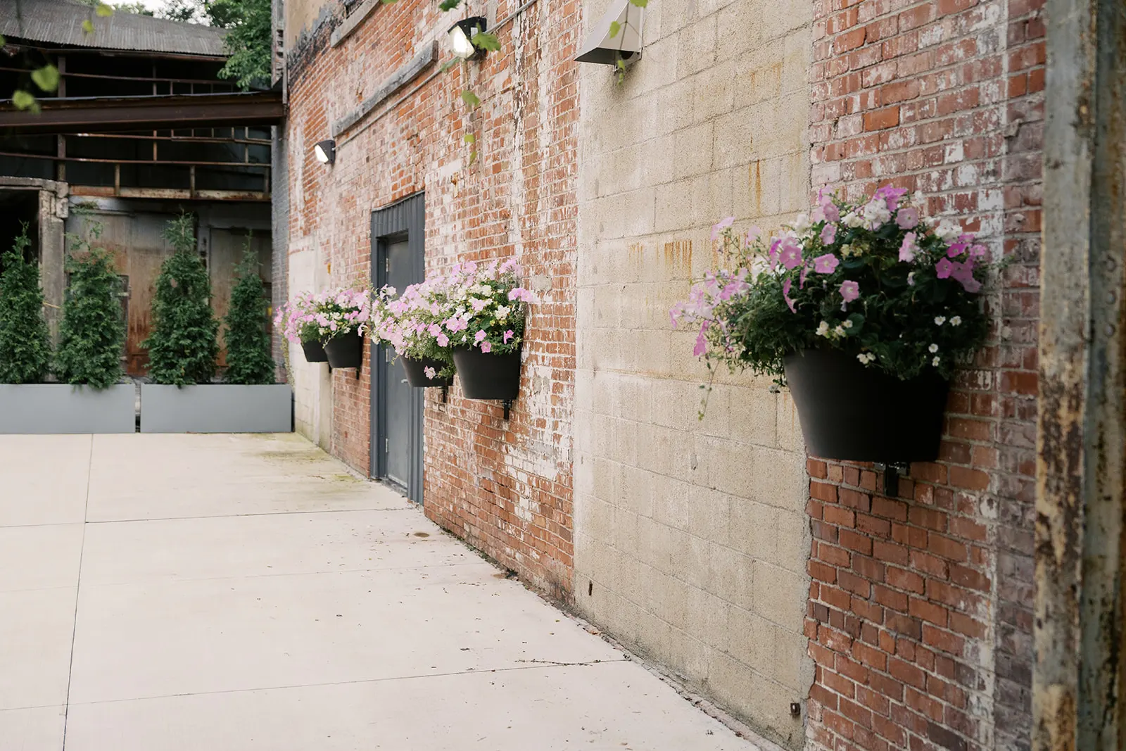 Brick courtyard wall with hanging flower baskets at Strongwater