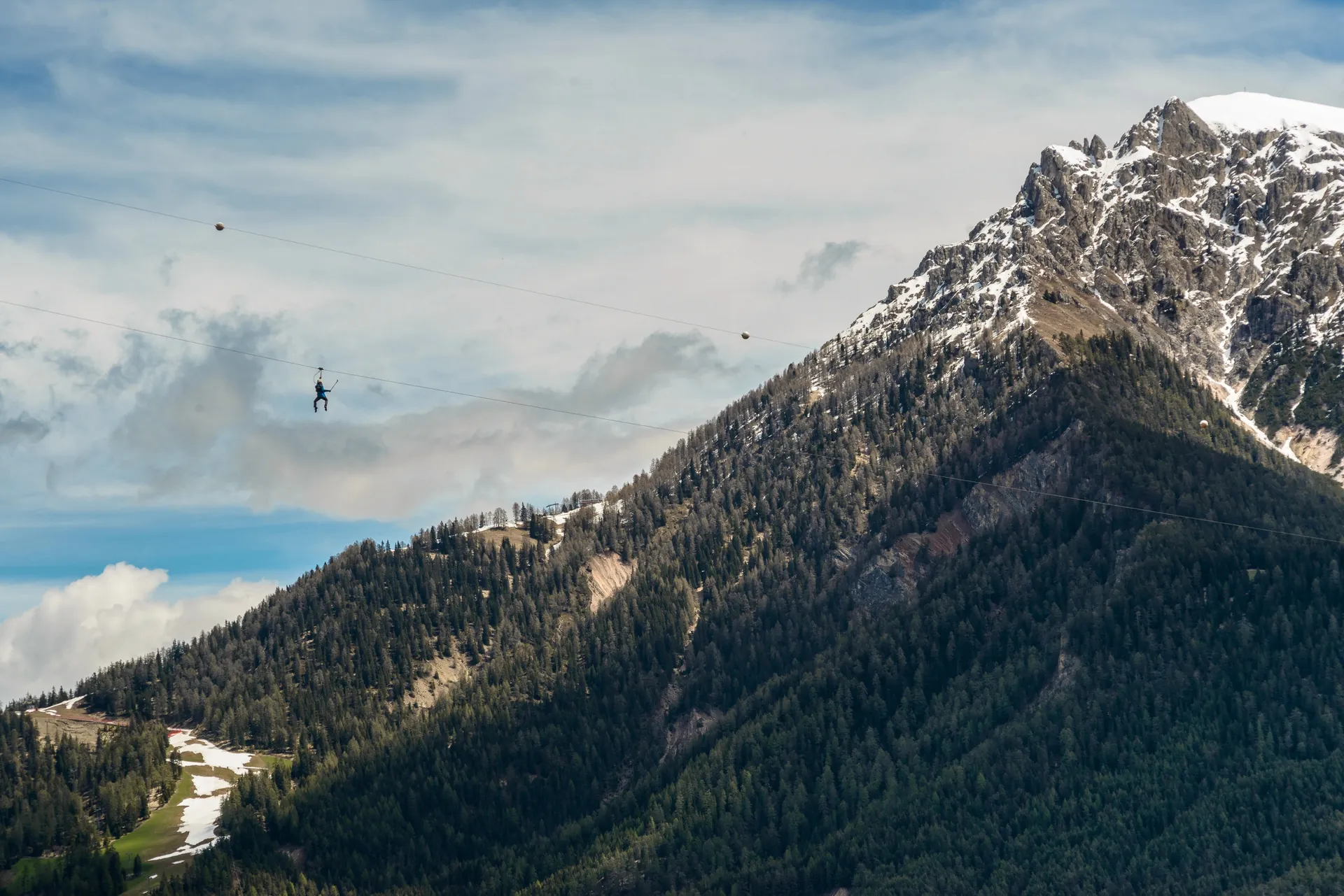 Zipline con panorama delle montagne innevate delle Dolomiti