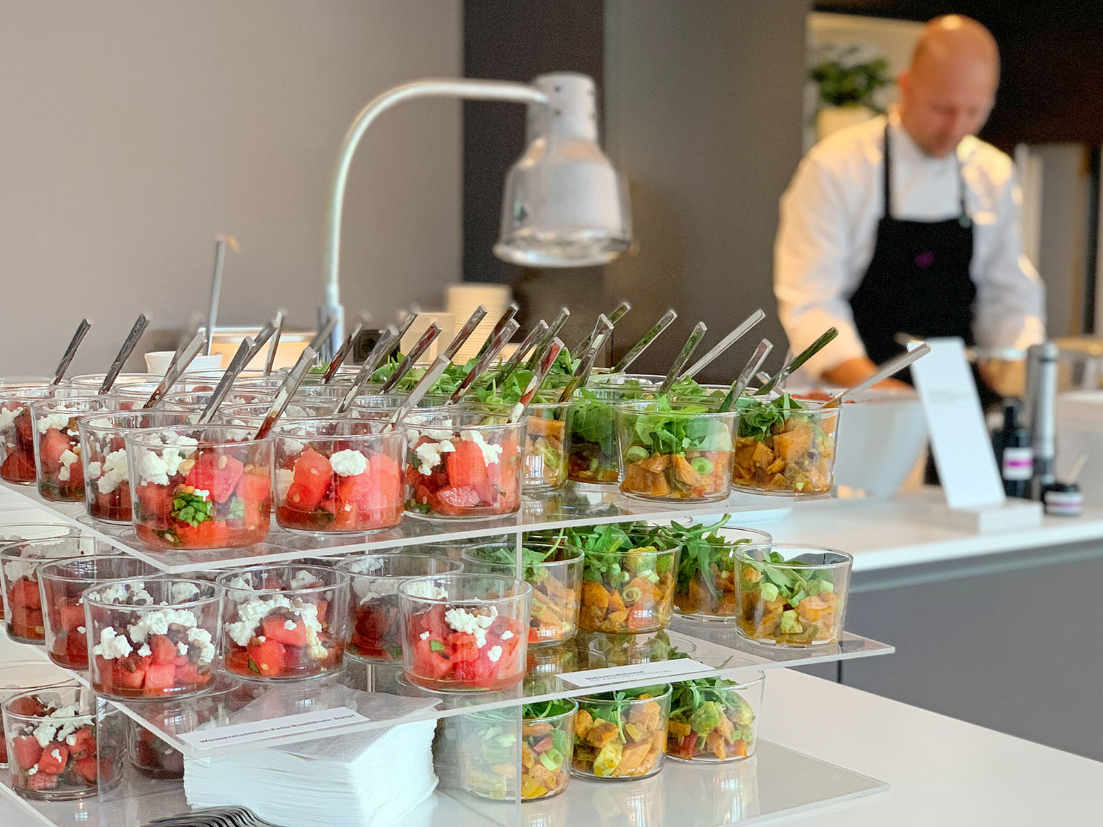 Koch an einer Live-Cooking-Station mit Fingerfood in Gläsern