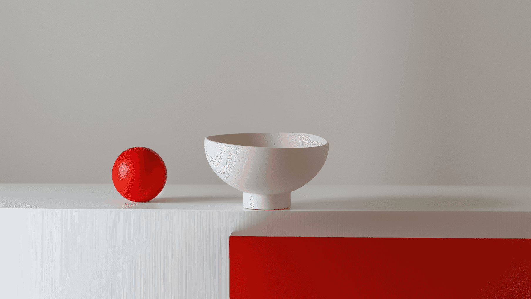 Minimalist scene with a red sphere and white bowl on a two-tone surface, blending modern design and color contrast.