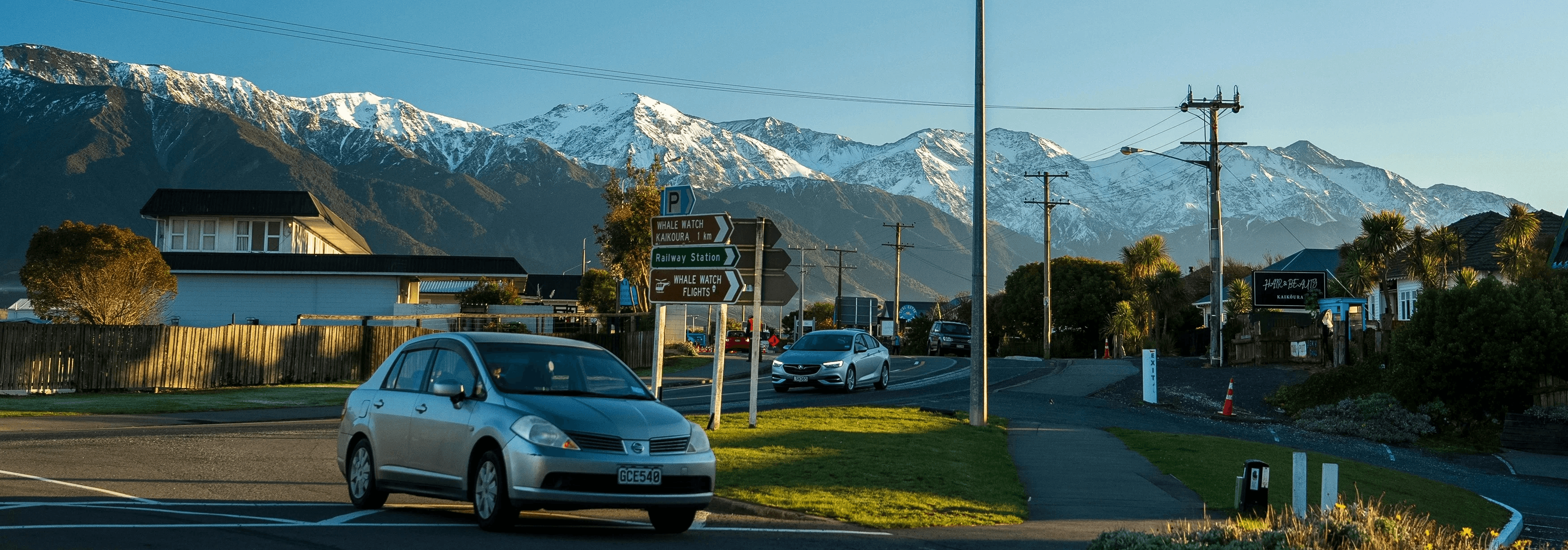 A car driving down a street with a mountain in the background