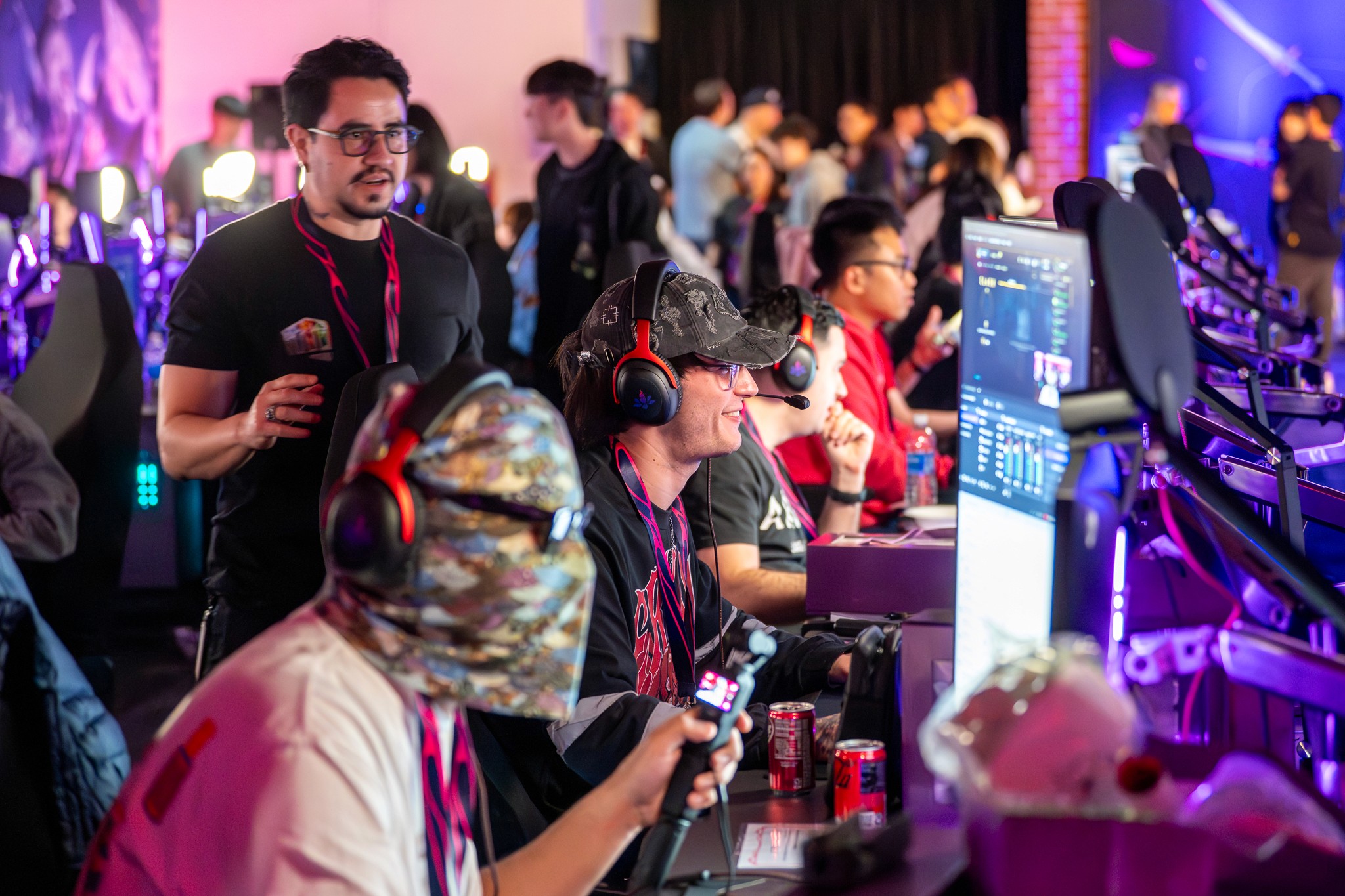 Event production crew member assisting a guest at a technical booth.