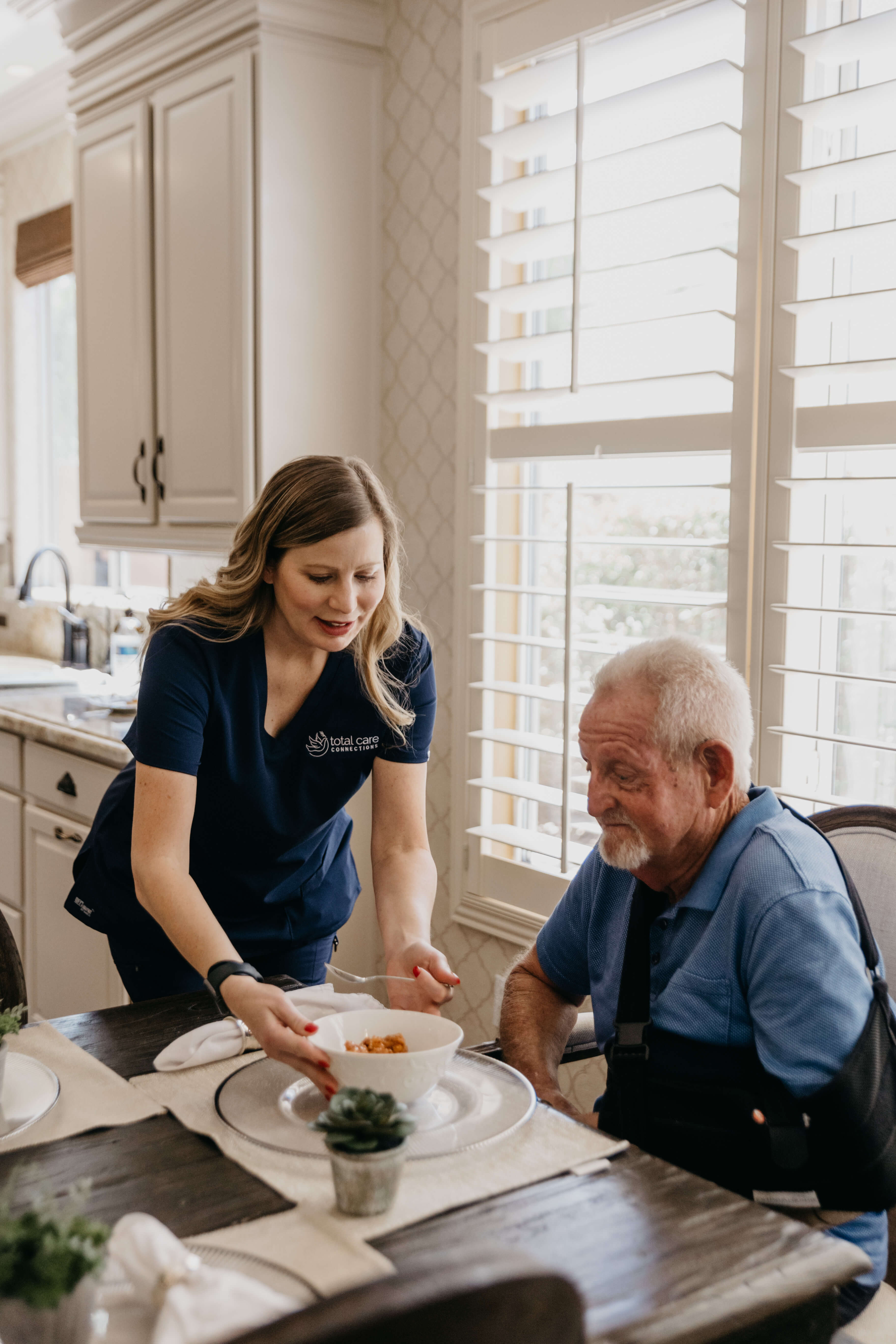 Total Care Connections Caregiver serving client some lunch.