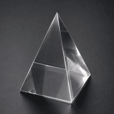 Glass pyramid on a dark matte office table