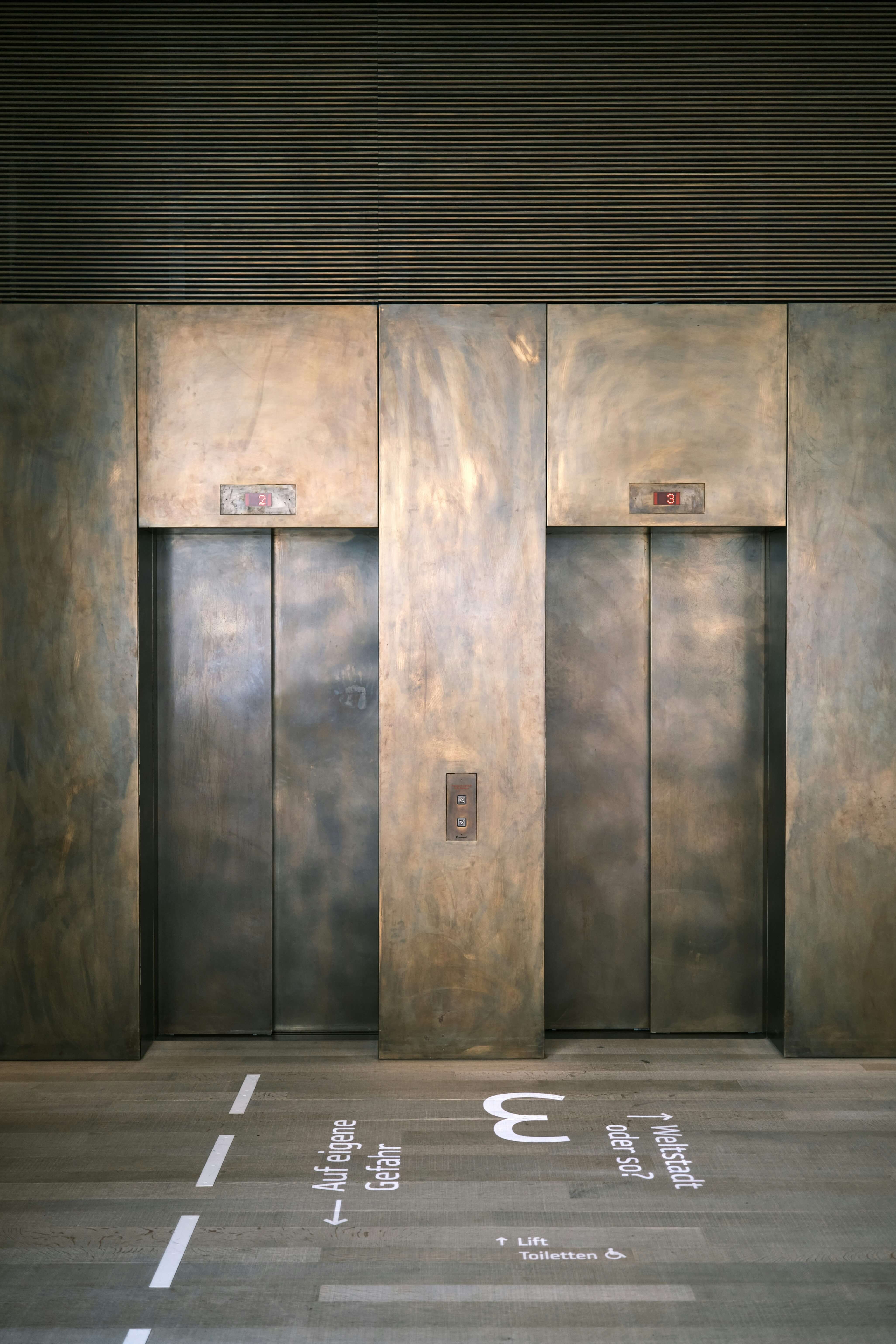 Symmetric image of modern elevator in heavy stone