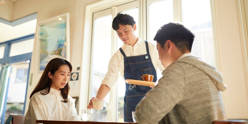 An F&B staff serving food to customers at a restaurant