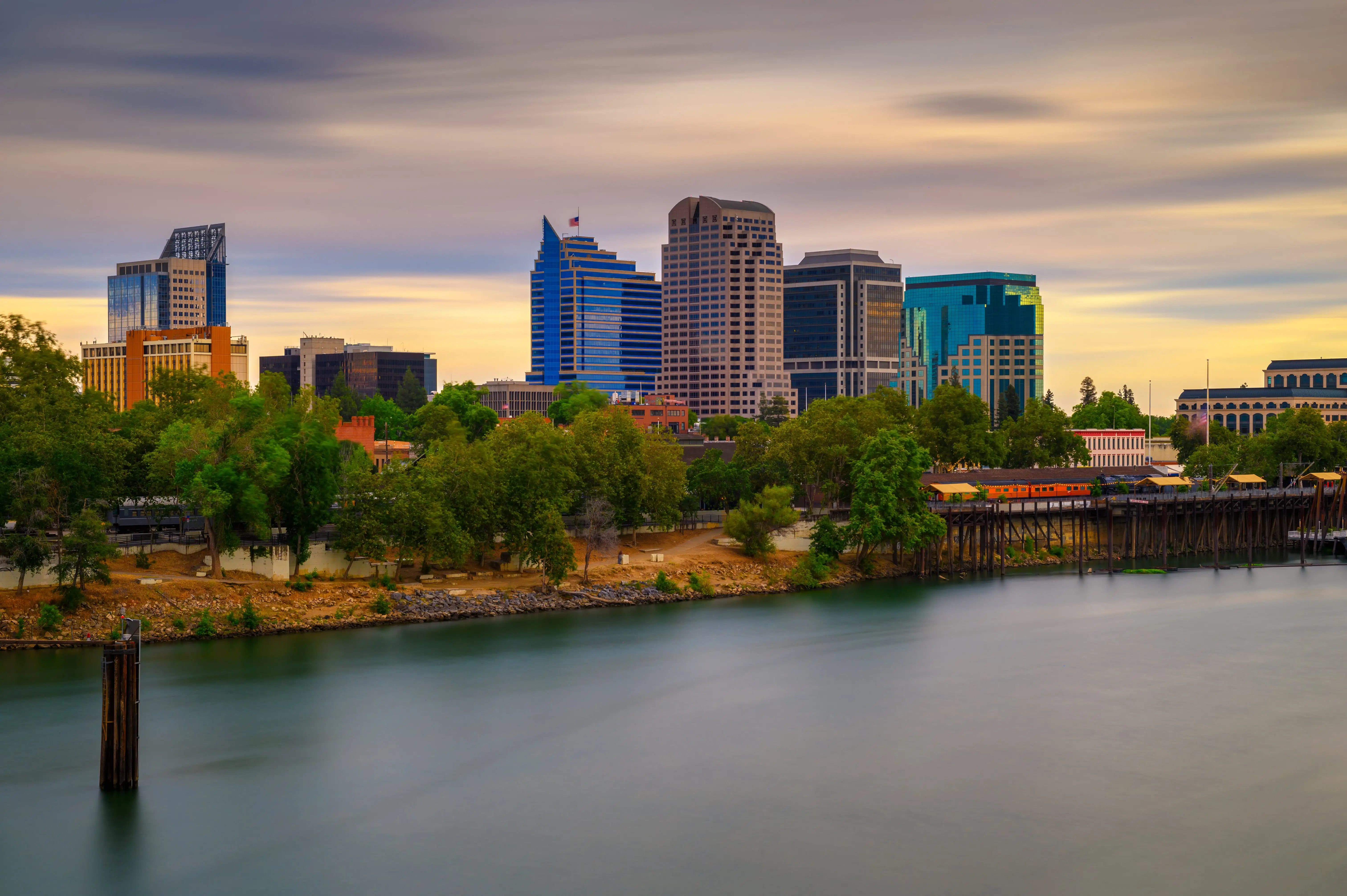 A panoramic view of Midtown Sacramento's skyline during sunset reveals modern living spaces in high-rise buildings.