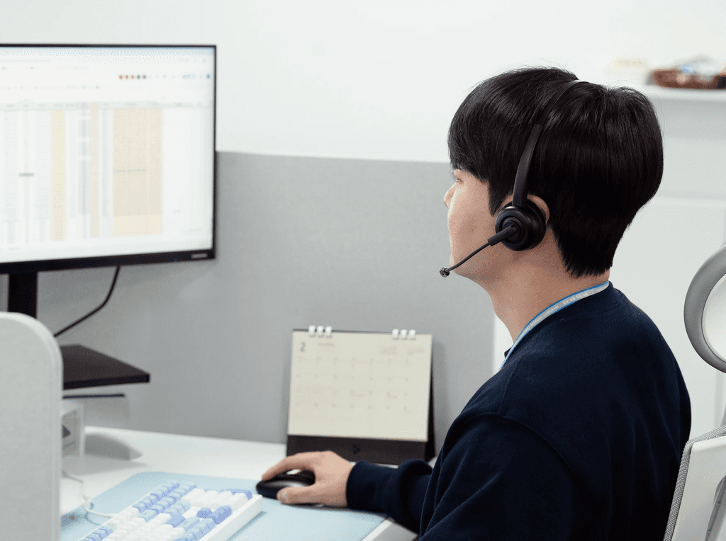 씨제이대한통운 더 운반 담당자가 헤드셋을 착용하고 운송 배차 및 운임 관련 업무를 처리하고 있습니다.