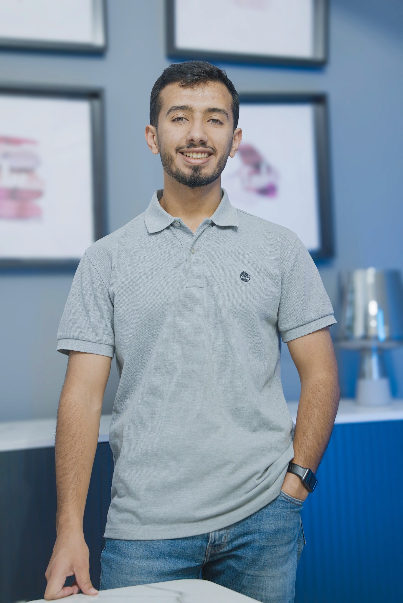 Woman working on a laptop computer at a table in a bright room.