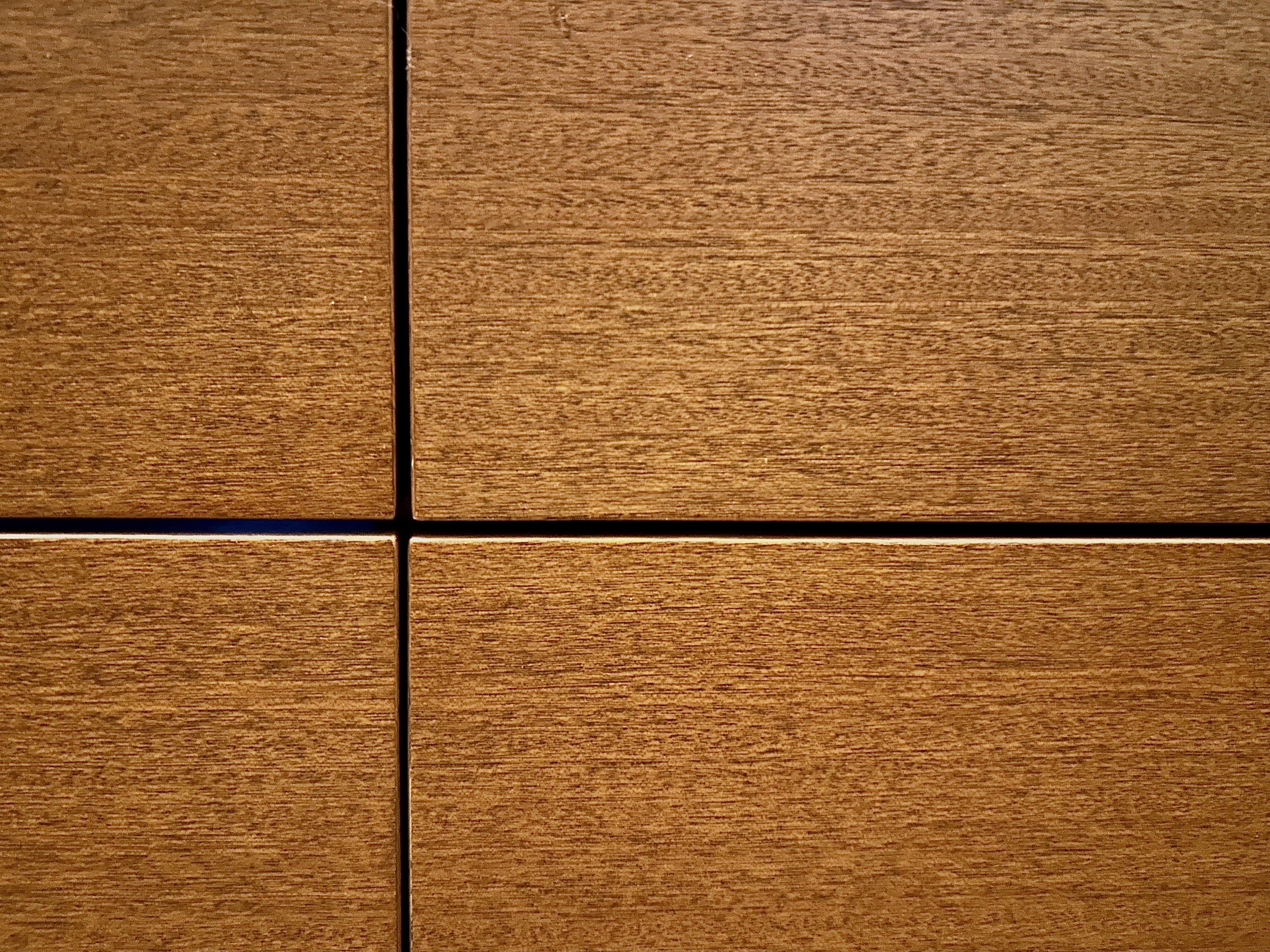 An up-close view of wooden drawers meeting.