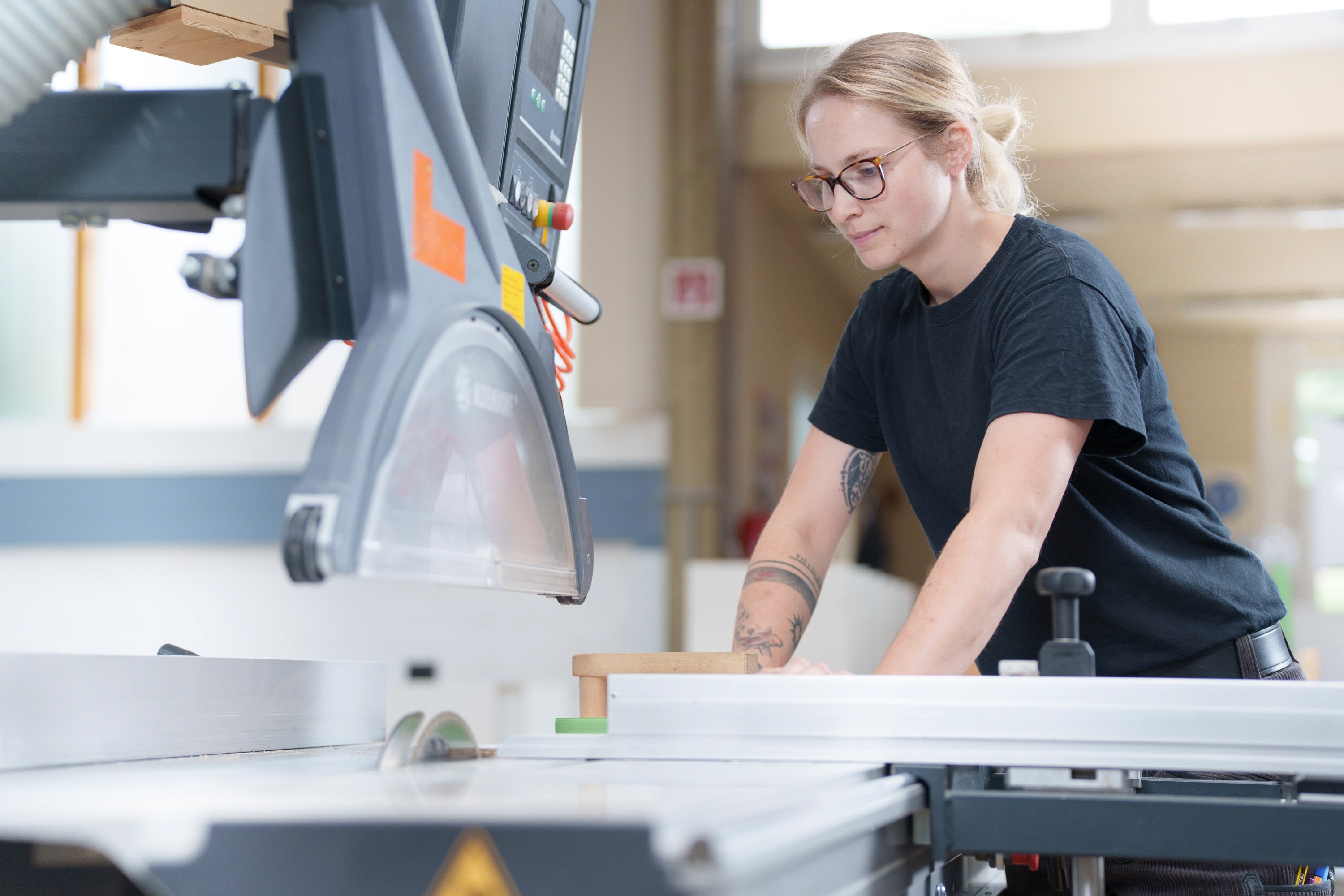 Mitarbeiterin arbeitet an einer Maschine in der Werkstatt