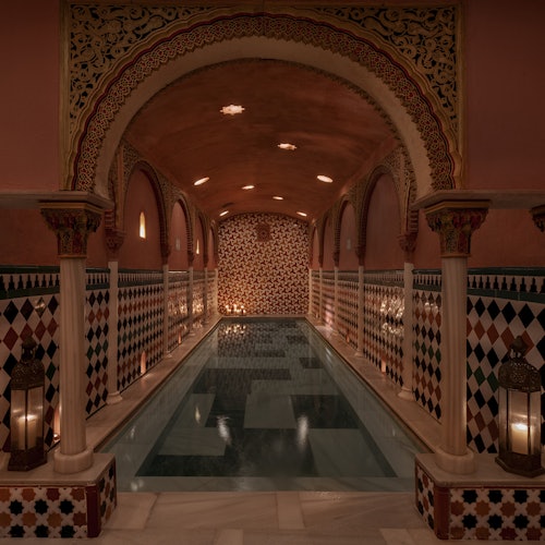 華麗的室內游泳池，擁有瓷磚牆壁、拱門、柱子和燈籠，營造出溫暖而誘人的氛圍。