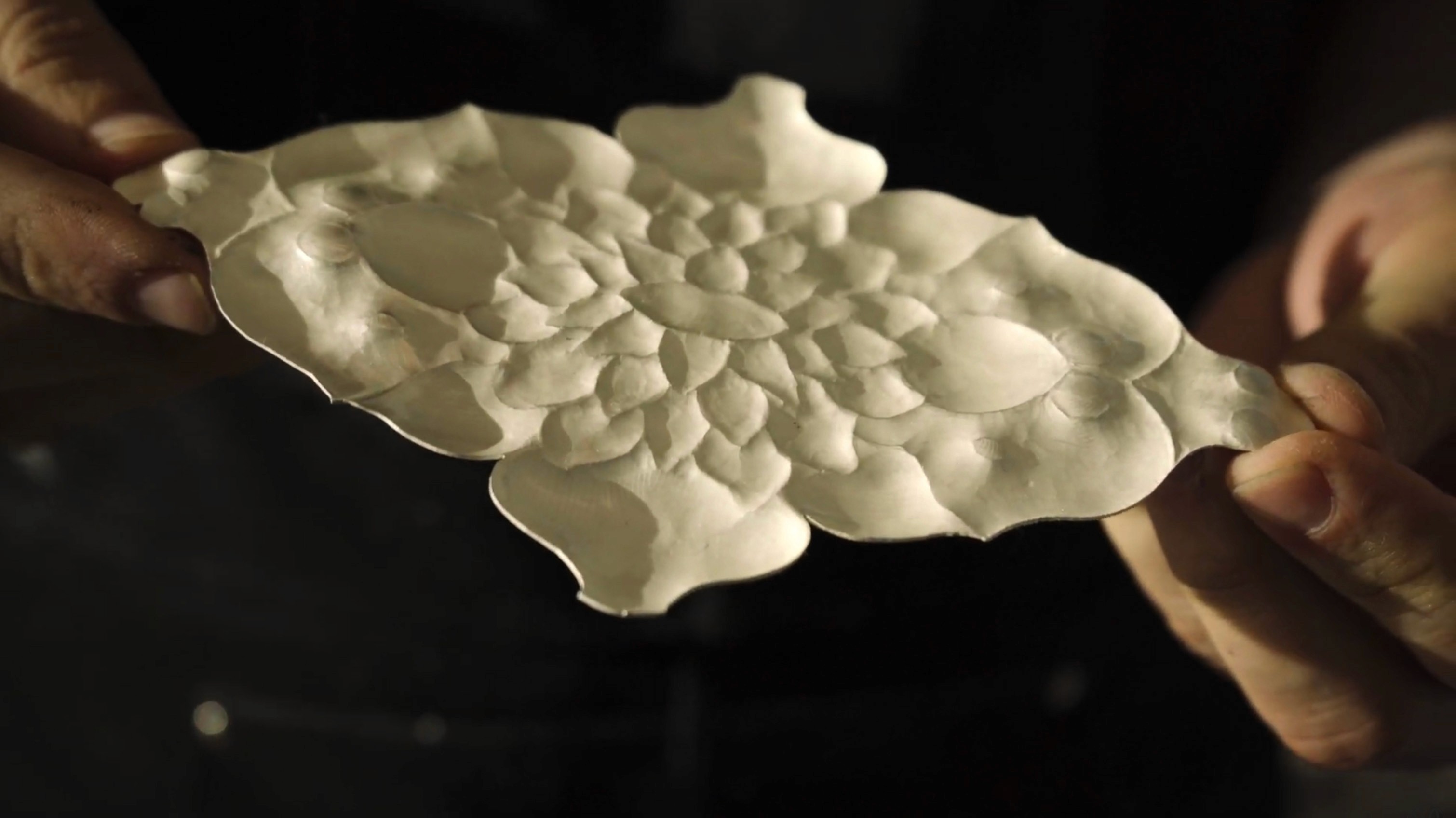 Close-up of a south asian woman in a red dress with dramatic side lighting during a cinematic performance.