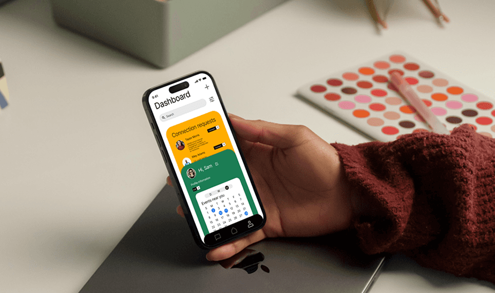 Person holding phone at desk