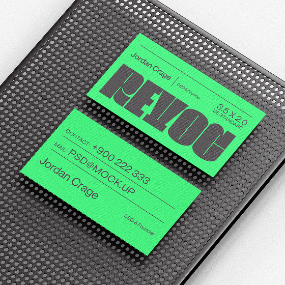 Neon green business cards on a perforated black metal tray.
