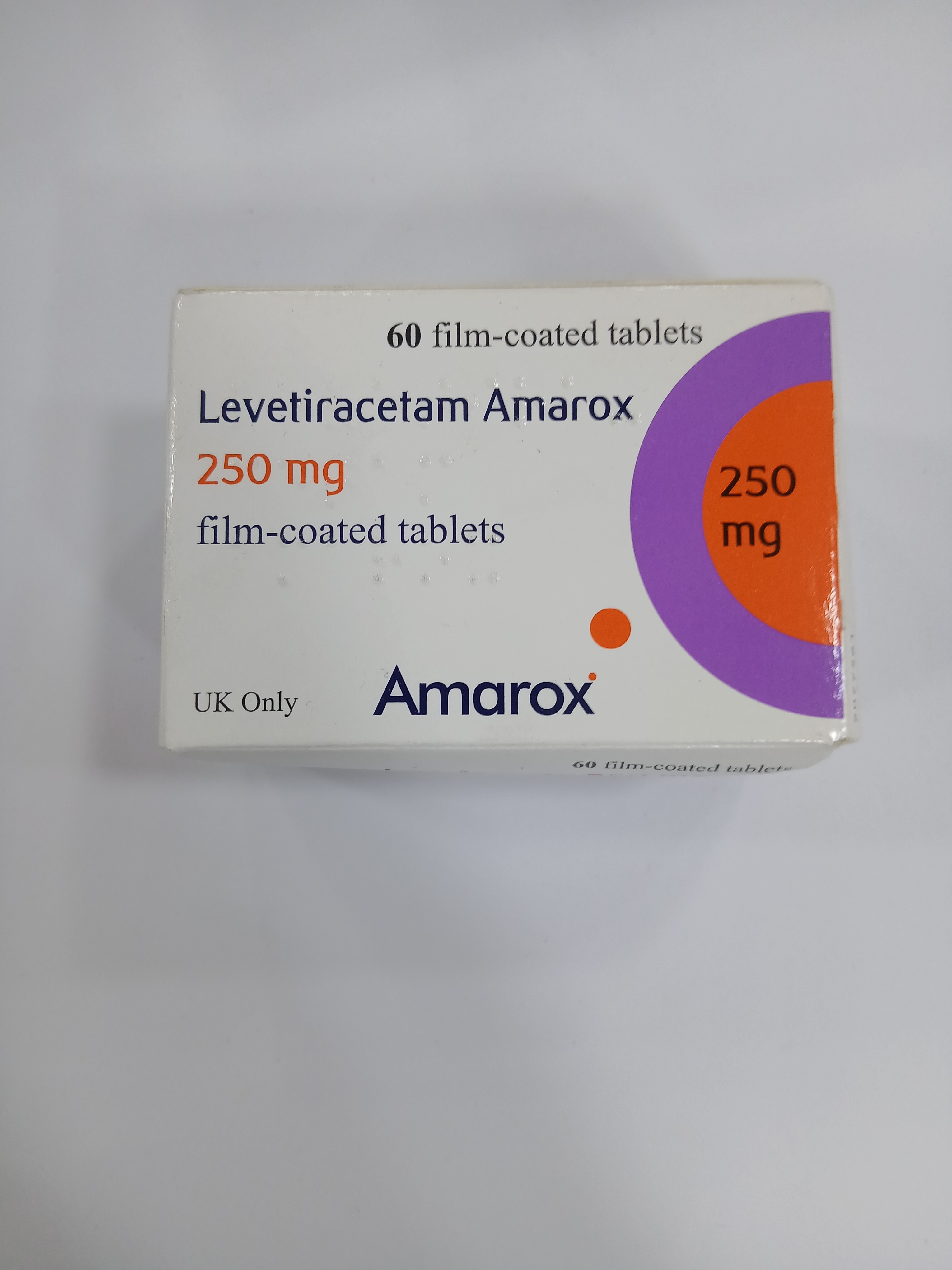 White cardboard box packaging displays a purple and orange circular design with text indicating it contains 60 film-coated tablets of 250 mg strength.