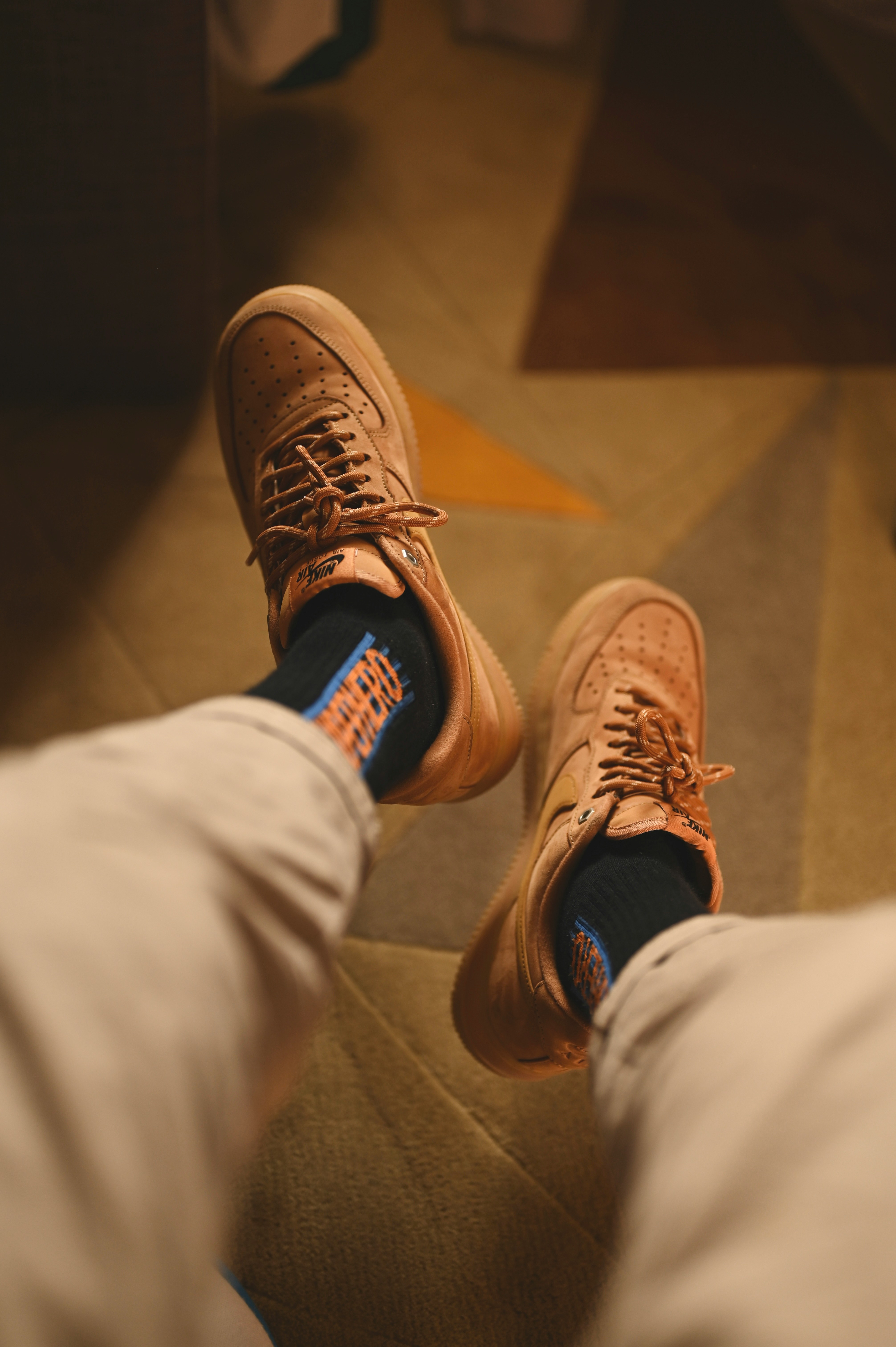 a person wearing brown sneakers and white pants
