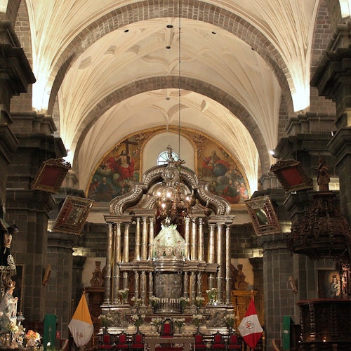 華麗的教堂內部，擁有宏偉的祭壇、細緻的拱門和宗教旗幟。場景中包括精美的雕刻和畫作。