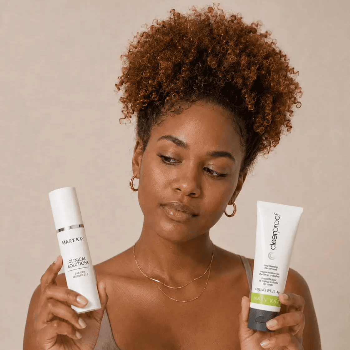 Cliente segurando produtos Mary Kay durante orientação de rotina de skincare