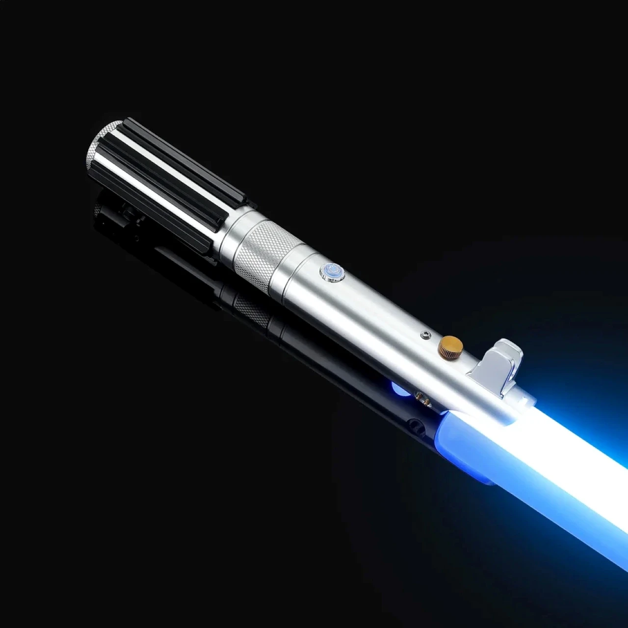 A glowing blue lightsaber with a silver and black hilt rests diagonally against a dark background, showcasing its sleek design and vibrant illumination.