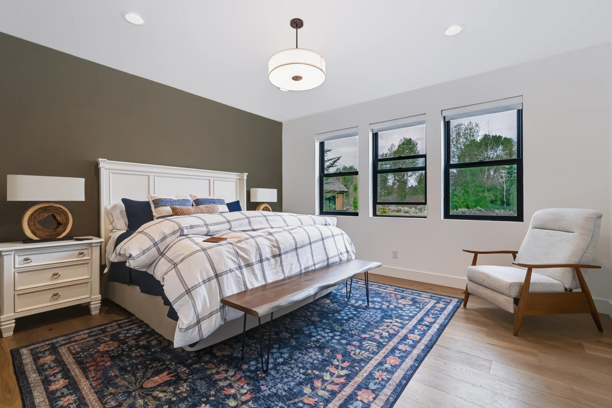 Bedroom with patterned rug and garden views