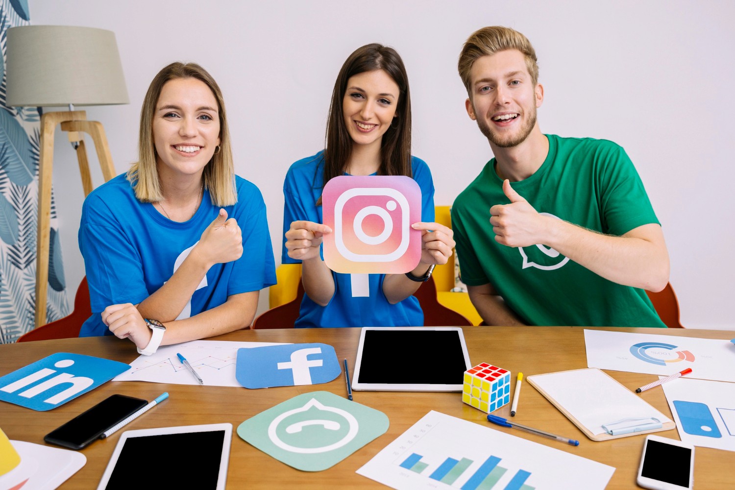 Three individuals proudly display various social media icons, symbolizing digital connectivity and engagement.