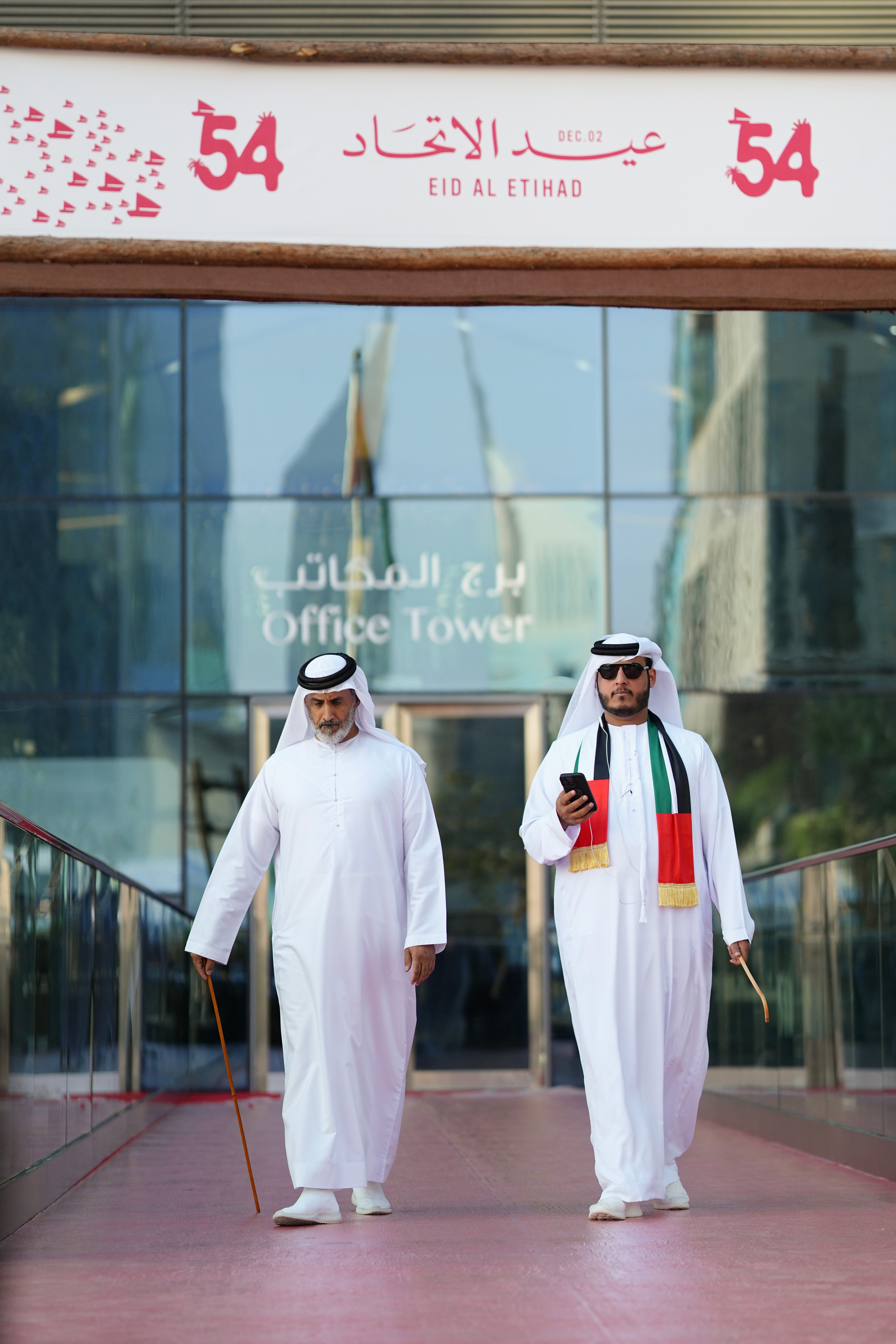 Female scientist wearing a white coat and gloves examines a sample slide in a modern laboratory setting.