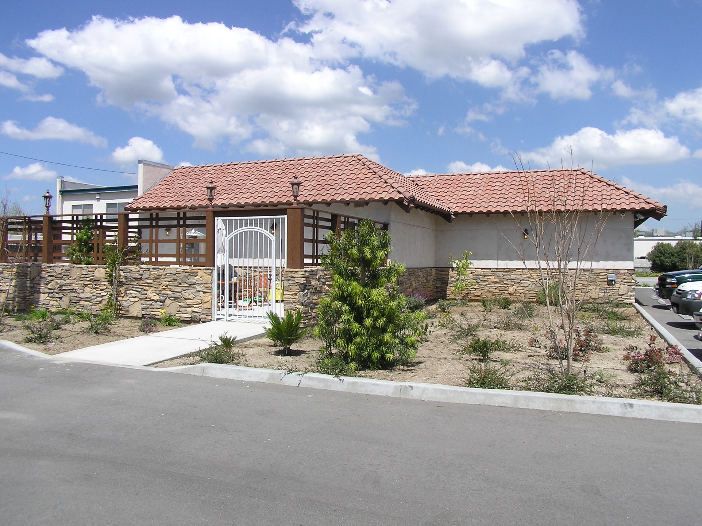 Exterior view featuring greenery and the building, emphasizing the integration of the natural surroundings with the rustic-inspired architecture.