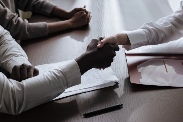 People shaking hands over a table