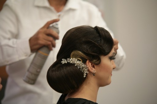 a woman getting her hair done by a hair stylist