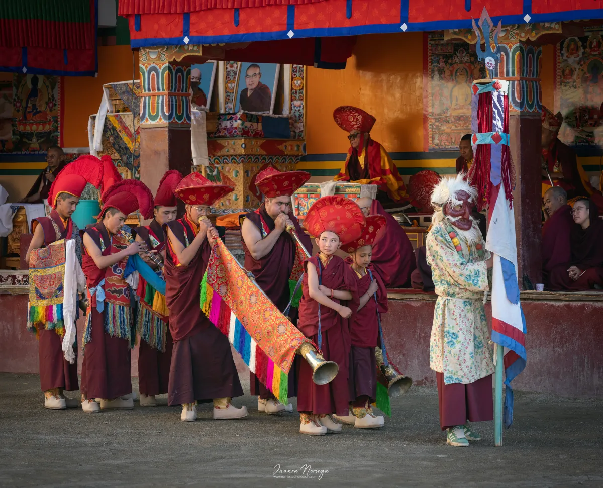 Monjes tocando largas trompetas tibetanas durante la danza cham de un festival en Ladakh