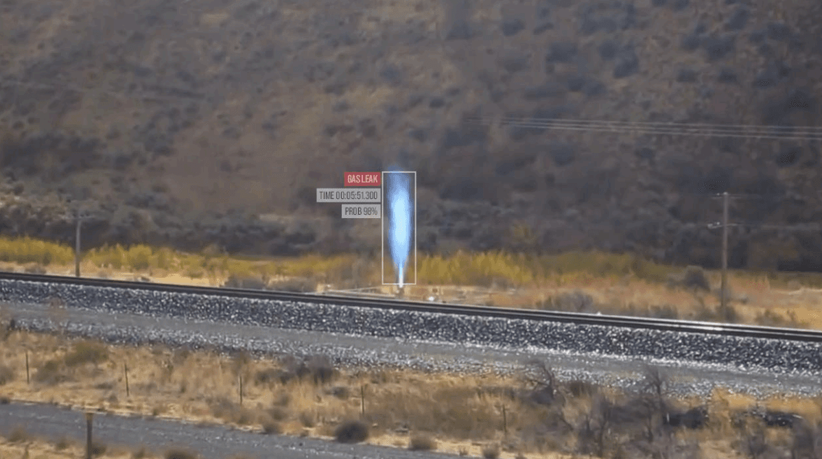 AI-based gas leak detection visualized through vapor plume analysis near a railway with safety alert signage