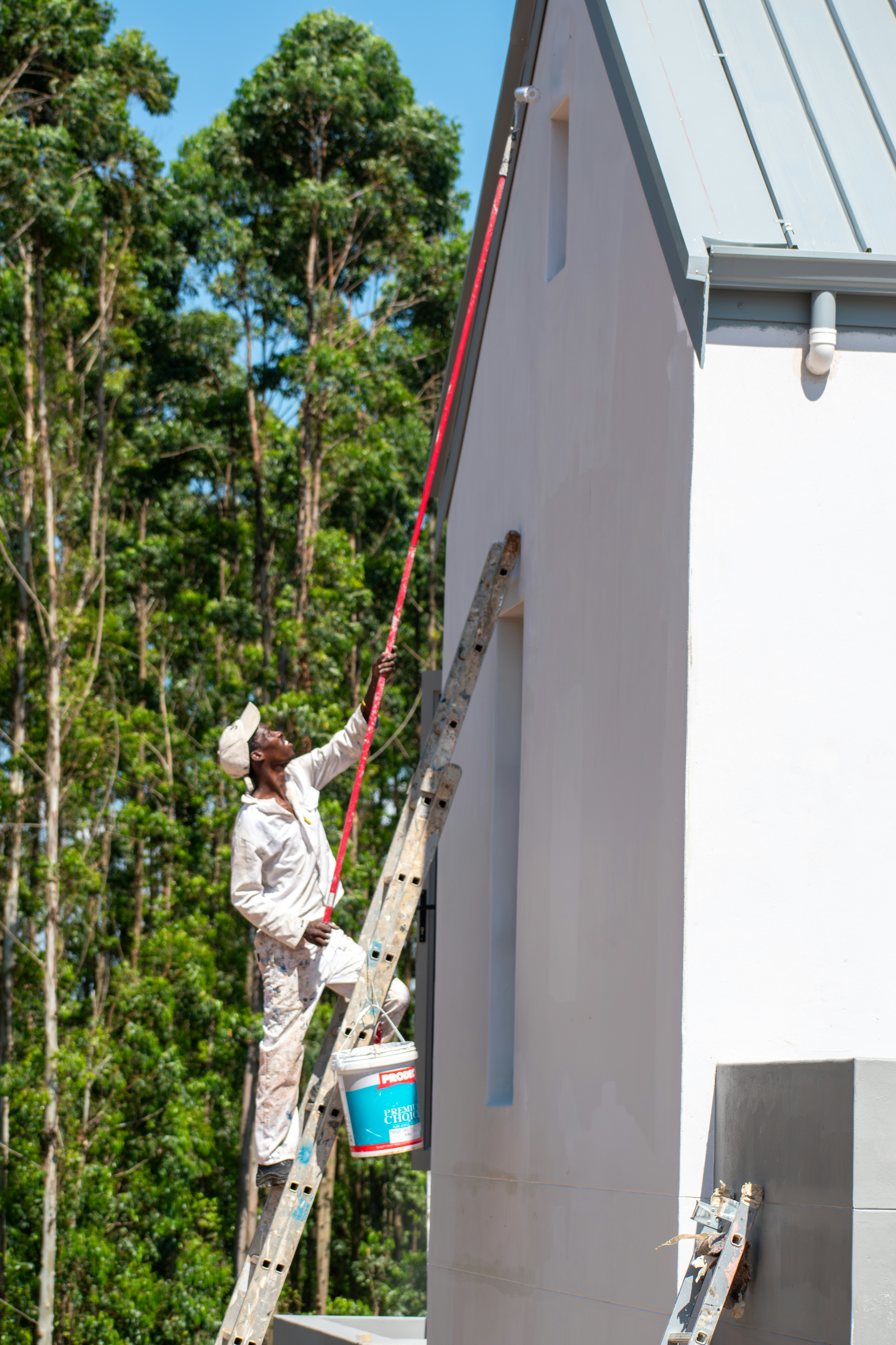 A painter is working on a building's exterior.
