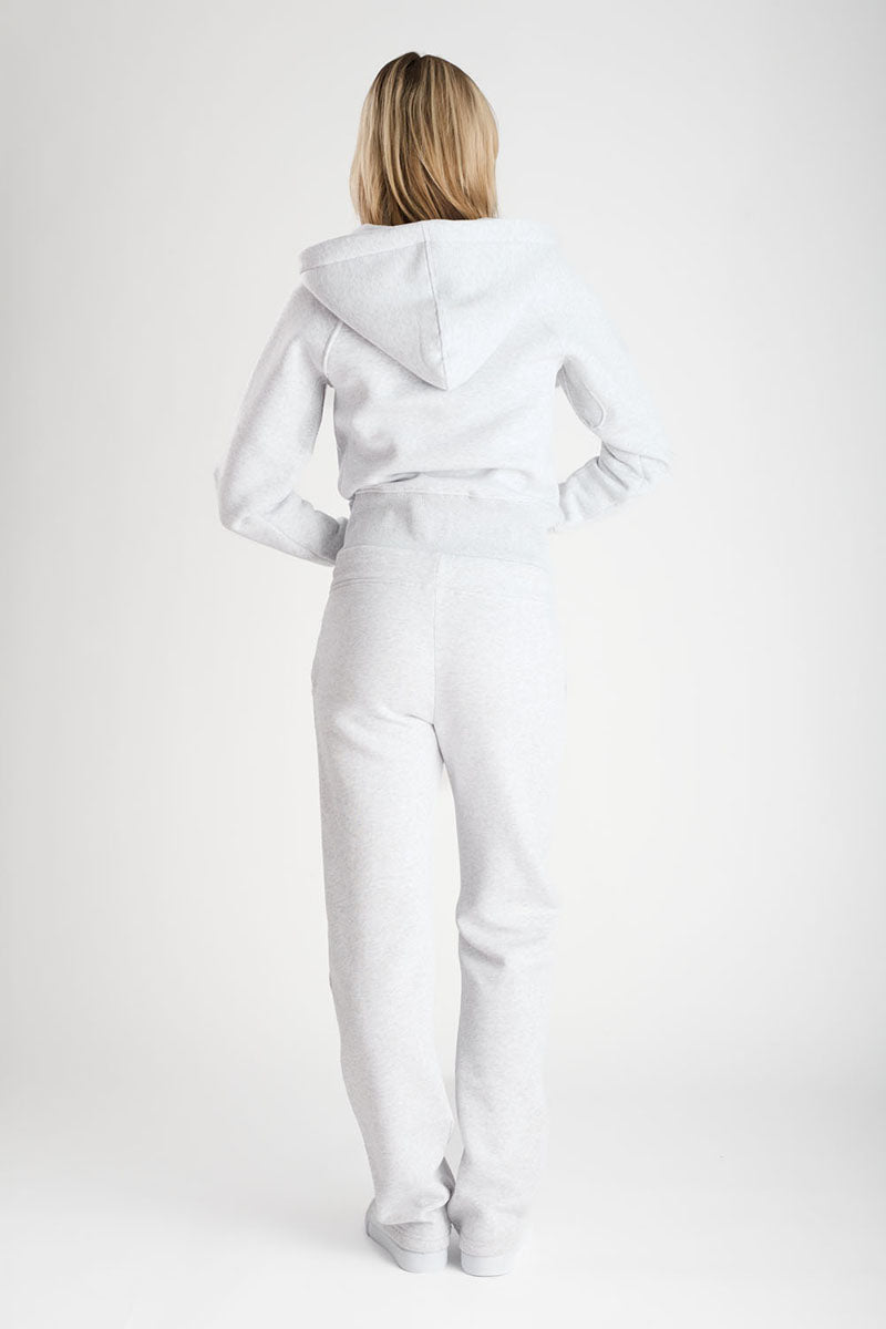 Person wearing a light grey outfit with a hood on a white background