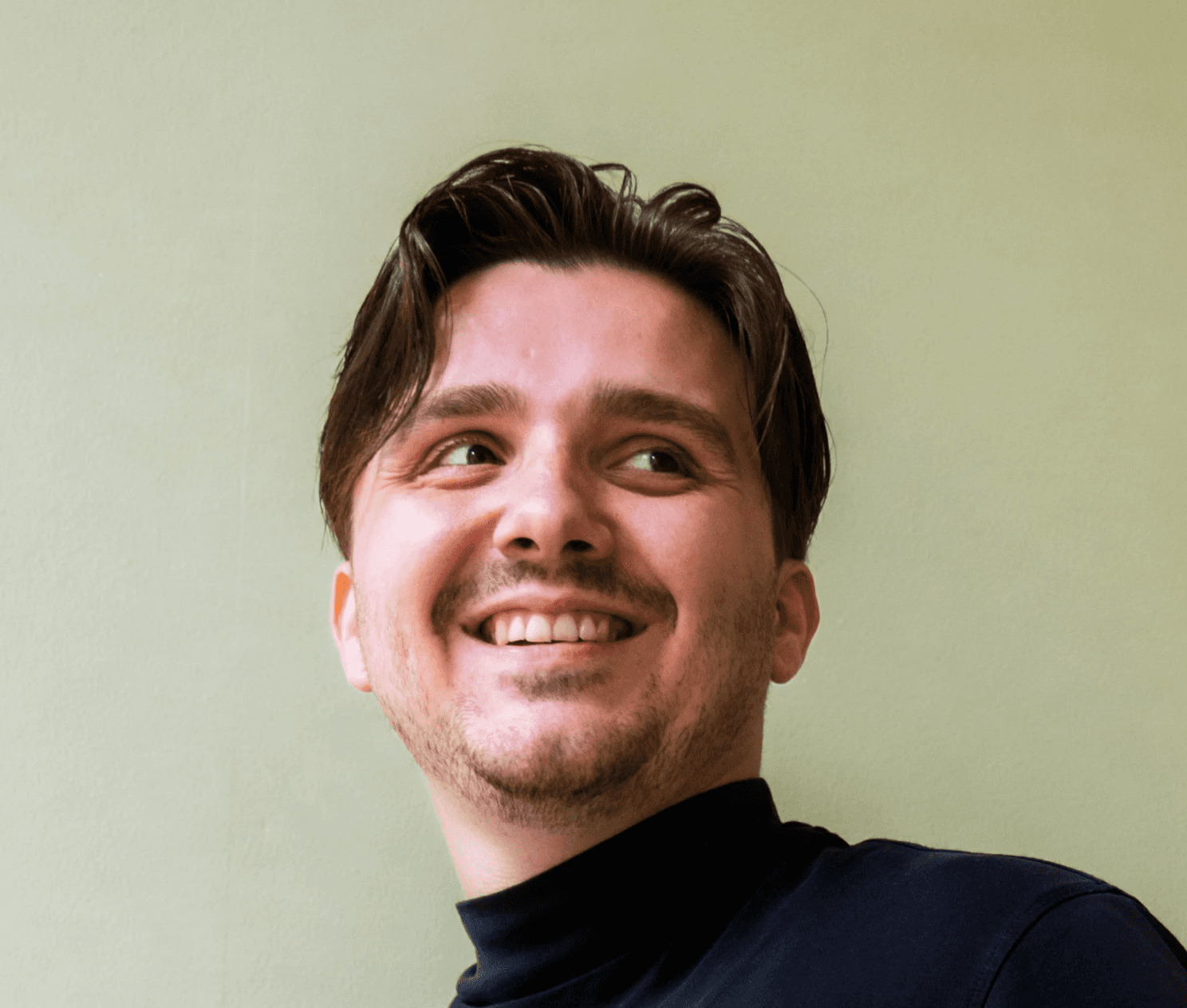 Profile portrait of a man in a white shirt against a light background