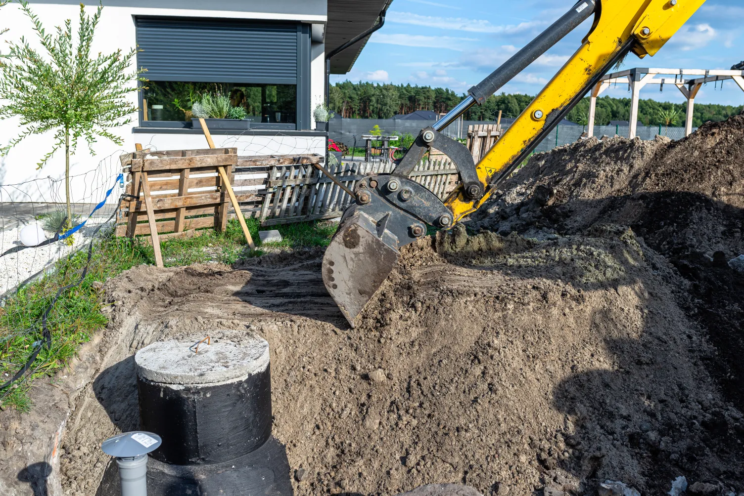 Bagger bei der Vorbereitung eines Hausanschlusses und der Kanalisation