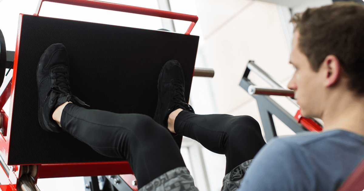 A person using a leg press machine in the gym