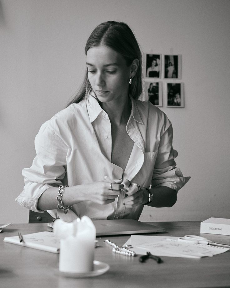 Portrait of Mia Cruz, New Business Manager, standing in a design studio with a material mood board behind her