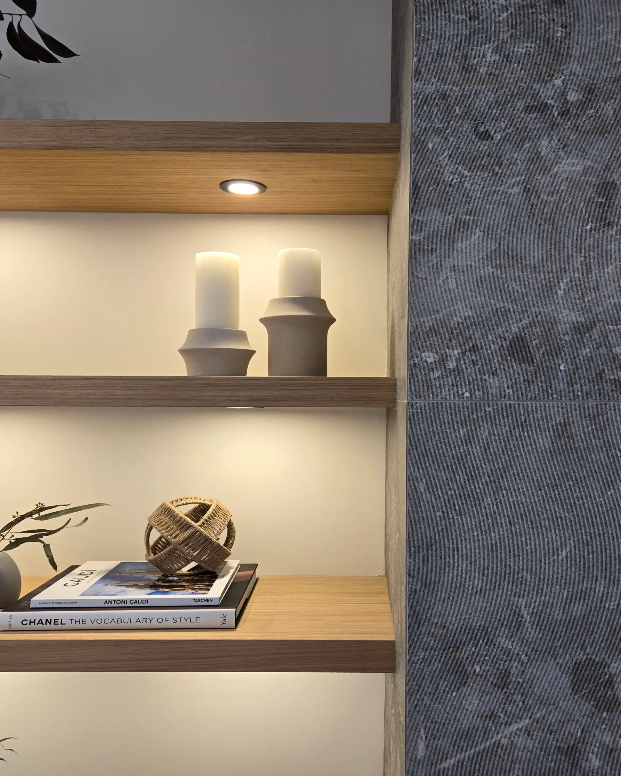 Image of open shelving beside a fireplace with textured grey tile.