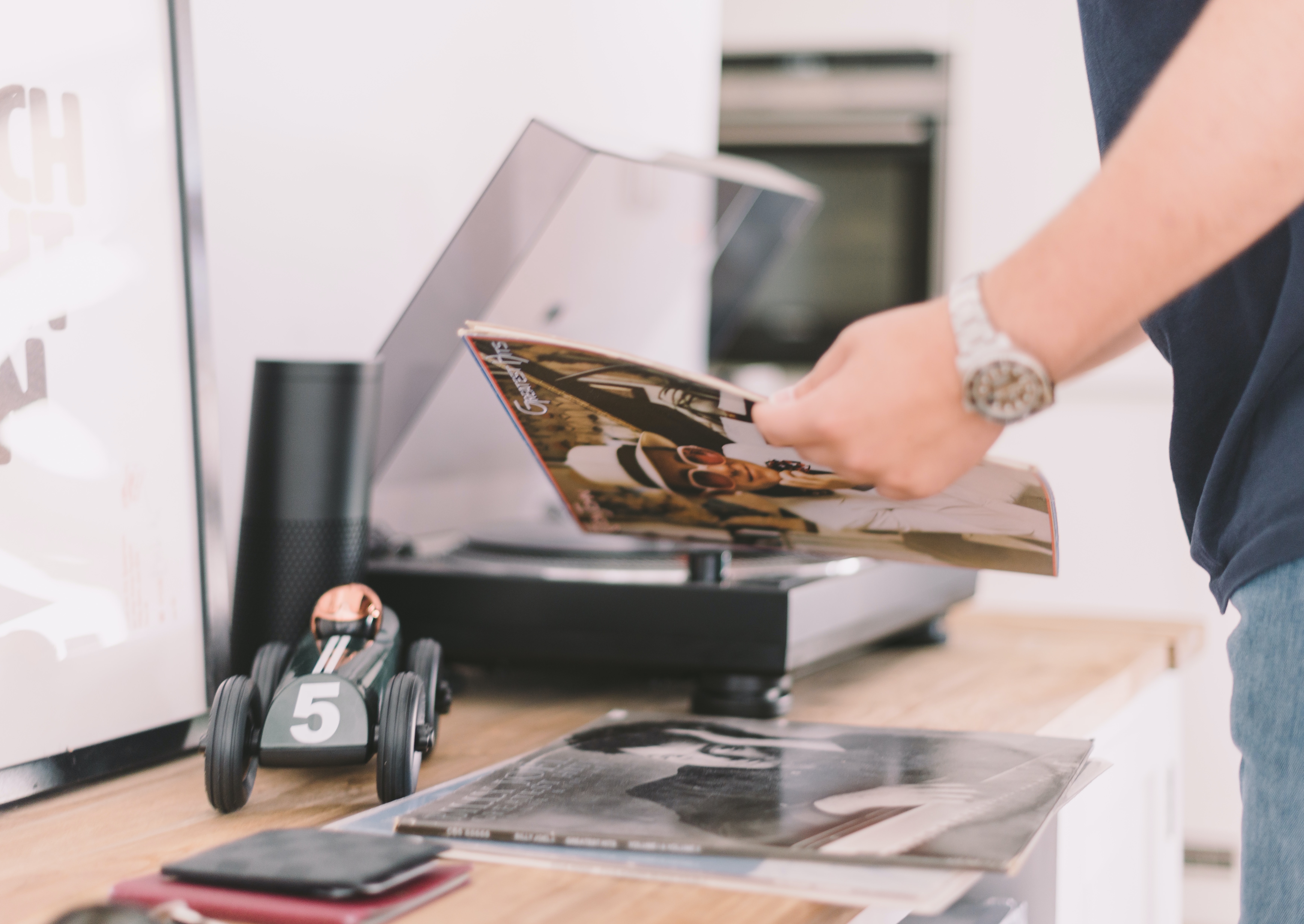 man reading a music magazine near a record player - ai music artist